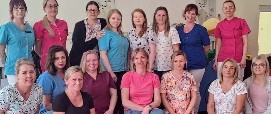 Opiekunowie żłobka wraz z fizjoterapeutką prowadzącą szkolenie z zakresu wiedzy fizjoterapeutycznej na temat rozwoju i wsparcia dziecka