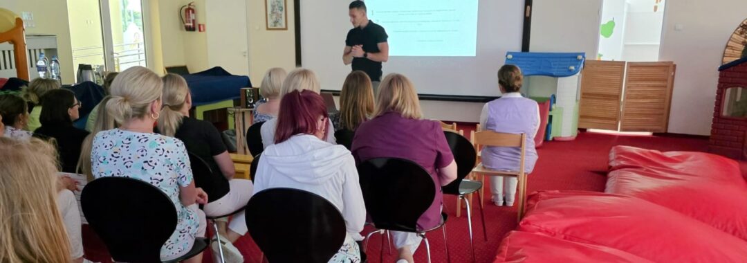 Grupa siedzących pracowników żłobka w trakcie wykładów prowadzonych przez dietetyka klinicznego.