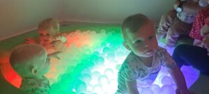 Dzieci bawią się piłeczkami w kąciku świetlnym.