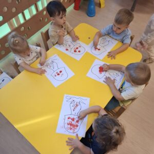 Dzieci ozdabiają kropkami kapelusz grzyba