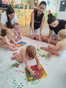 Dzieci malują farbami.