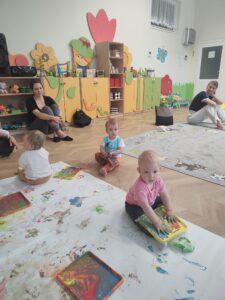 Dzieci malują farbami.