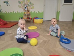 Dzieci siedzą na podłodze na krążkach.