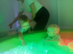 Dzieci bawią się piłeczkami w kąciku świetlnym.