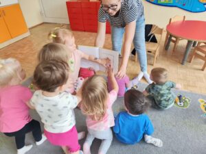 Czytanie dzieciom siedzącym na dywanie przez Panią bibliotekarkę.