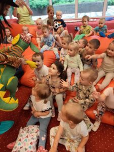 Dzieci podają rękę kukiełce smoka