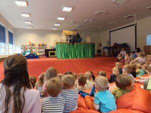 Scena z teatrzyku przedstawiająca smoki z widoczną publicznością