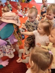 Dzieci podają rękę kukiełce smoka