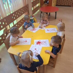 Dzieci ozdabiają kropkami kapelusz grzyba