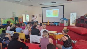 zdjęcie przedstawia grupę opiekunów w trakcie szkolenia prowadzonego przez psychoterapeutkę. 