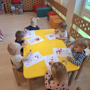 Dzieci ozdabiają kropkami kapelusz grzyba