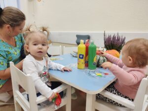 Dzieci bawią się woreczkami, które wypełnione są farbą.