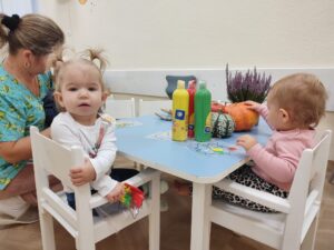 Dzieci oglądają dynie i wrzosy.