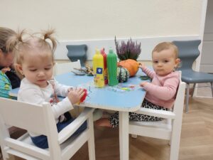 Dzieci bawią się Woreczkami strunowymi wypełnionym farbami w jesiennych kolorach.