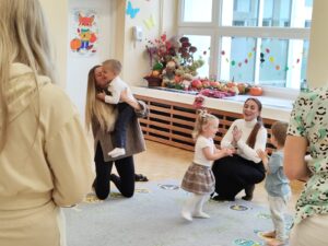 Dzieci z rodzicami podczas zajęć- biją brawo oraz się przytulają