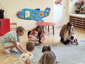 Dzieci z rodzicami podczas zajęć- bawią się kasztanem