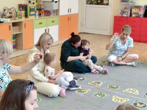 Dzieci z rodzicami podczas zajęć- bawią się kasztanem