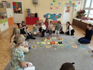 Dzieci losują z worka i sortują na dywanie dary jesieni