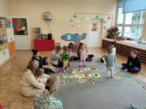 Dzieci losują z worka i sortują na dywanie dary jesieni