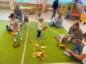 Jesienna zabawa dzieci w żłobku na zielonym dywanie
