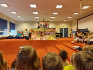 Widok sceny wraz z postaciami z perspektywy widowni