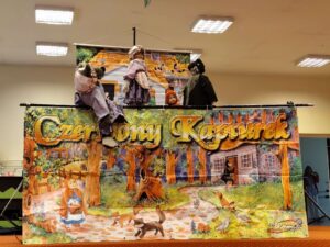 Scena przedstawienia wraz z kukiełkami- babcią, czerwonym kapturkiem, wilkiem i myśliwym