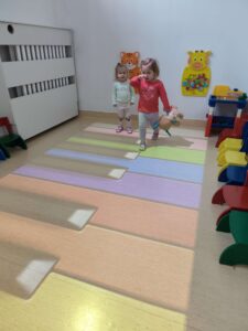 Dzieci bawią się na magicznym dywanie- biegają po klawiszach pianina