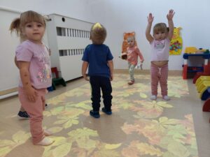 Dzieci bawią się na magicznym dywanie- na jesiennych liściach