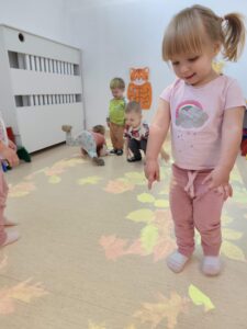 Dzieci bawią się na magicznym dywanie- na jesiennych liściach