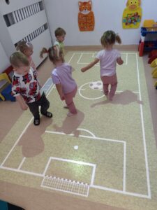 Dzieci bawią się na magicznym dywanie- grają w piłkę