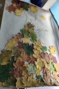 Skończona praca plastyczna- sylwetą pani jesieni wyklejona świeżymi liśćmi