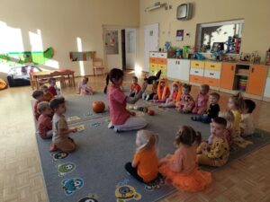 Pani pokazuje dzieciom małą dynię