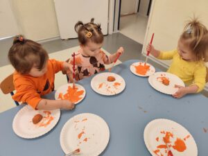 Dzieci malują na pomarańczowo łupinkę orzecha