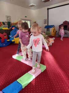 Dzieci idą po ułożonym torze z piankowych kostek