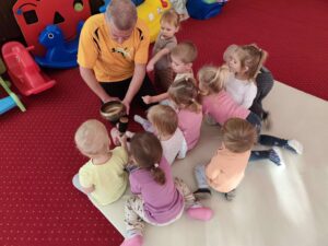 Dzieci uderzają w misę siedząc na materacu