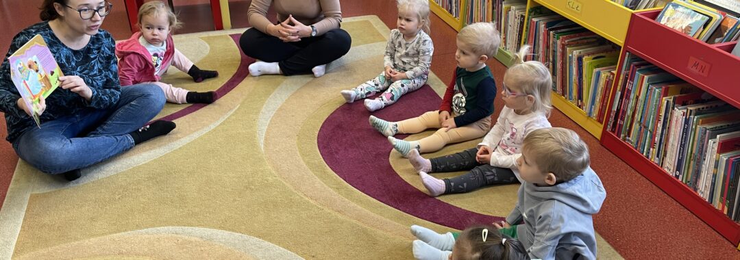 Pani z biblioteki czyta dzieciom książeczkę