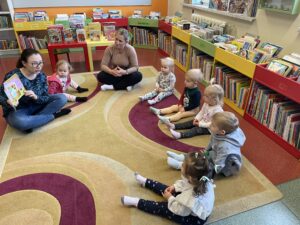 Pani z biblioteki czyta dzieciom książeczkę