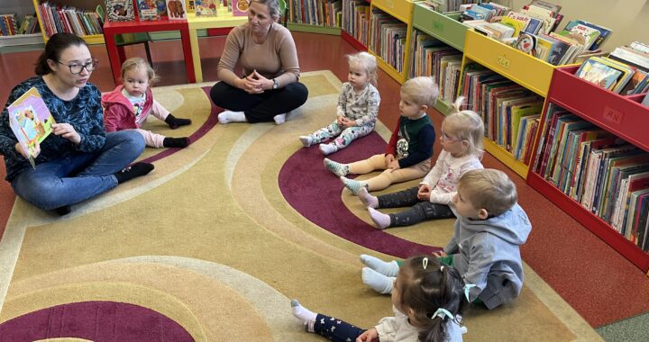Pani z biblioteki czyta dzieciom książeczkę