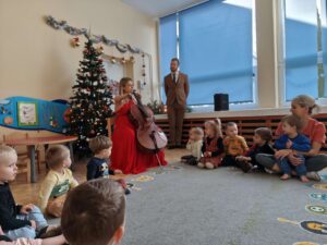 Pani gra dla dzieci kolędy na wiolonczeli.