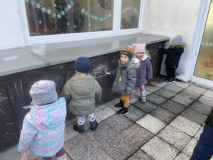 Dzieci na spacerku w ogrodzie żłobka