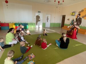 Pani gra dla dzieci kolędy na wiolonczeli.