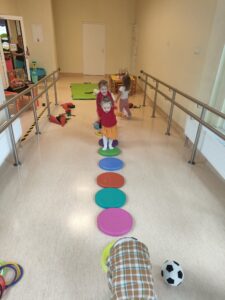 Dzieci skaczą po kolorowych okręgach