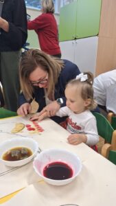 Dziewczynka maluje z babcią laurkę