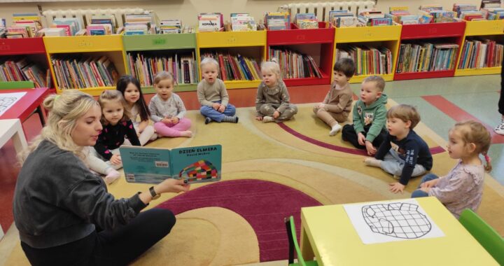 Dzieci w bibliotece słuchają książki czytanej przez panią