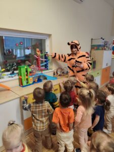 Dzieci pokazują palcem na ukrytą postać Kubusia