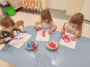 Dzieci malują farbami postaci z Kubusia Puchatka