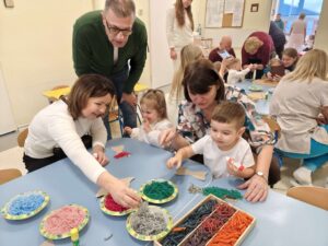 Dzieci wykonują pracę plastyczną wraz z dziadkami