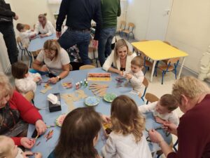 Dzieci wykonują pracę plastyczną wraz z dziadkami