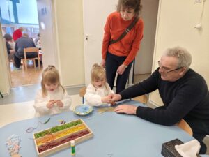 Dzieci wykonują pracę plastyczną wraz z dziadkami