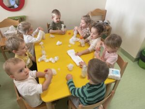 Dzieci wykonują bałwanki z butelek.